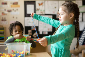 Preschool girl threading beads